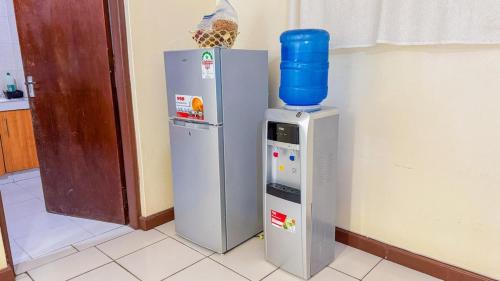 a refrigerator and a water cooler next to a wall at The Rosebay Apartment in Mombasa