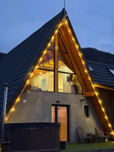 a house with string lights on the roof at Cabana Forestia - ciubăr inclus in Copalnic Mănăştur