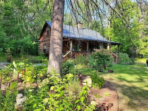 a log cabin in the middle of a yard at Deer Valley Retreat, Lovely Log Cabin with Fireplace & Garden Views- Perfect for a Relaxing Getaway! in Bradford
