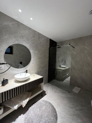 a bathroom with a sink and a mirror and a shower at ICH Inveja Country House in Paços de Ferreira