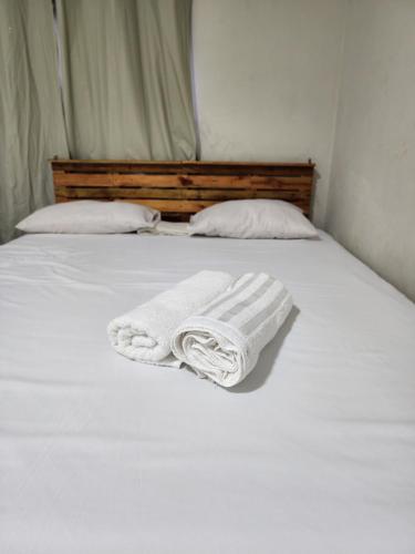a bed with two white towels sitting on it at Pousada Cactus in Barreirinhas