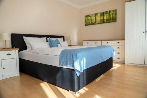 a bedroom with a large bed with a blue blanket on it at Hotel & Restaurant Zum Reussenstein in Böblingen