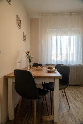 a dining room table with four chairs and a window at Hotel & Restaurant Zum Reussenstein in Böblingen