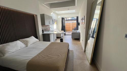 a bedroom with a bed and a sink and a mirror at Luxurious London Studios in Harrow