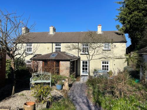 an old house with a bench in front of it at Vauxhall Cottage, Chepstow - 4 Bedroom Pet-Friendly Home with Private Fenced Garden, Walk to Town and Castle in Chepstow