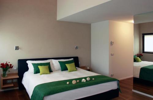 una camera da letto con un letto grande con cuscini verdi e bianchi di La Posa degli Agri a Legnaro