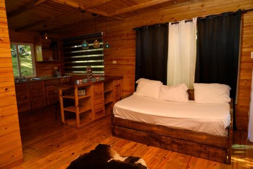a bedroom with a bed in a log cabin at villas ecologicas hacienda vista linda in Cabrera