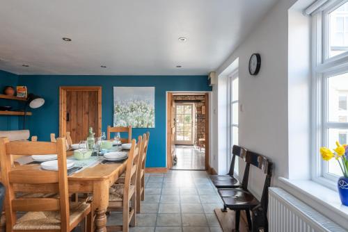a dining room with a wooden table and chairs at Vauxhall Cottage, Chepstow - 4 Bedroom Pet-Friendly Home with Private Fenced Garden, Walk to Town and Castle in Chepstow