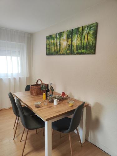 a dining room table with chairs and a painting on the wall at Hotel & Restaurant Zum Reussenstein in Böblingen