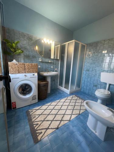 a bathroom with a washing machine and a toilet at Casa Zuccaro in Valduggia