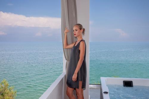 a woman in a dress standing next to a window at Akrotiri Olympus Luxury Suites - Adults Only in Plaka Litochorou