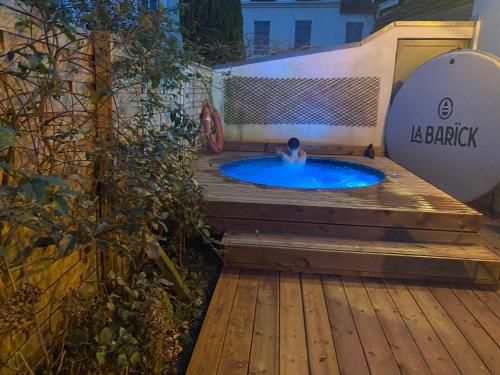 a person in a hot tub on a wooden deck at côte et mer et Spa in Sainte-Adresse