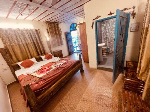 a bedroom with a bed and a door to a bathroom at The Blue House in Jodhpur