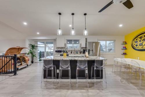 a kitchen with a large island with bar stools at Pop Art Oasis with Karaoke Mini Golf Hot Tub and Pool in Arvada