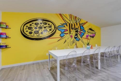 a dining room with a table and a painting on the wall at Pop Art Oasis with Karaoke Mini Golf Hot Tub and Pool in Arvada