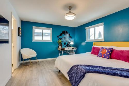 a bedroom with blue walls and a bed with pink pillows at Pop Art Oasis with Karaoke Mini Golf Hot Tub and Pool in Arvada