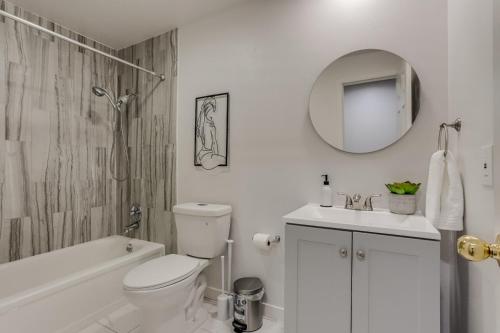 a bathroom with a toilet and a sink and a mirror at Pop Art Oasis with Karaoke Mini Golf Hot Tub and Pool in Arvada