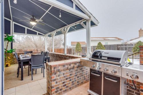 a patio with a grill and a table and chairs at Pop Art Oasis with Karaoke Mini Golf Hot Tub and Pool in Arvada