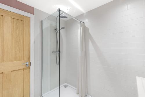 a shower with a glass door in a bathroom at Magpie Cottage - North East Escapes in Stanhope
