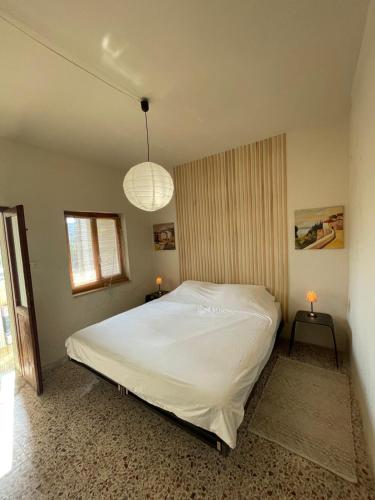 a bedroom with a large white bed with two tables at Casa Zuccaro in Valduggia