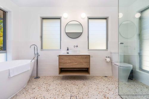 a bathroom with a tub and a sink and a mirror at Rubys on Rajah Family Friendly in Ocean Shores in Ocean Shores