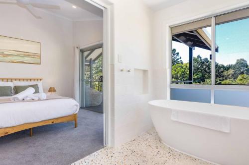 a bedroom with a bed and a bath tub next to a window at Rubys on Rajah Family Friendly in Ocean Shores in Ocean Shores