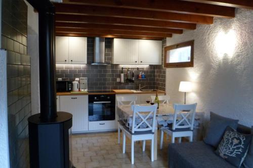 une cuisine avec une table, des chaises et une cuisinière dans l'établissement Chalet des Trois Ours, à Cauterets