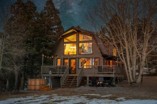 a cabin in the woods at night with a large window at The Aspen Ridge Stargazer in Cripple Creek