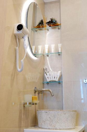 a bathroom with a sink with a phone and a mirror at Sykea Luxury Apartment in Xylokastro
