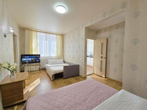 a hotel room with two beds and a television at У центрі 2 кімнатна квартира біля ЦУМу з власною закритою парковкою. Мережа Alex Apartments in Poltava