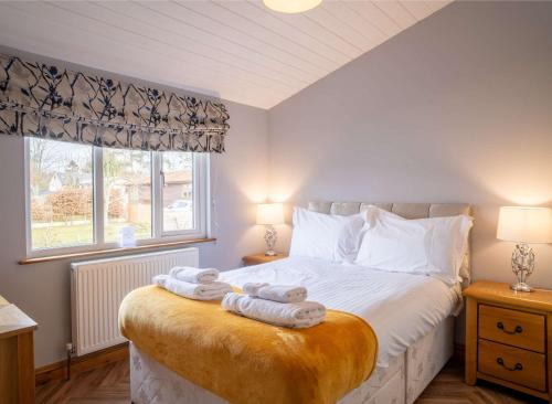 une chambre avec un lit avec deux serviettes dessus dans l'établissement Nualas Lodge Private Hot Tub Escape, à Wilberfoss