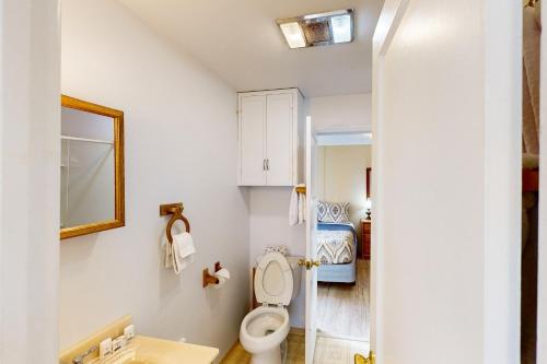 a bathroom with a toilet and a bed at Auntie's House in Rockaway Beach