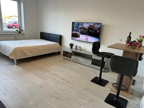 a bedroom with a bed and a flat screen tv at KOMFORT FerienWohnung NeuBau Merzig in Merzig