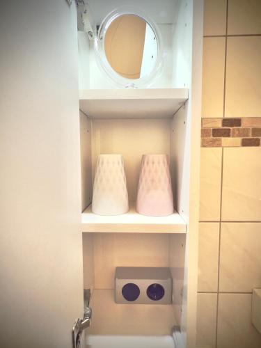 a bathroom with a toilet with a mirror on a shelf at Duhnerherz Bestlage im Zentrum,am Strand Duhnen, Balkon mit Meerblick,Wlan Parkplatz und Fahrradabstellraum Bettwäsche und Handtücher inkl in Cuxhaven