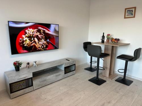 a living room with a television on a wall at KOMFORT FerienWohnung NeuBau Merzig in Merzig