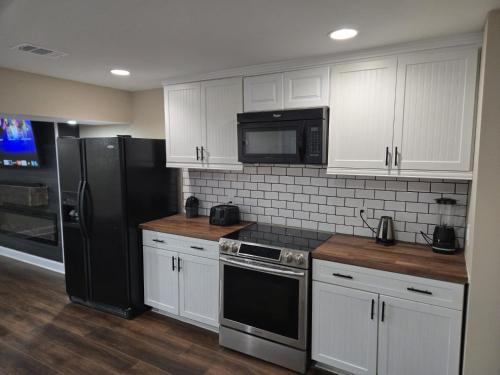 a kitchen with white cabinets and a black refrigerator at Gorgeous Guest Suite in Marietta!! Minutes from Historic Marietta Square in Marietta
