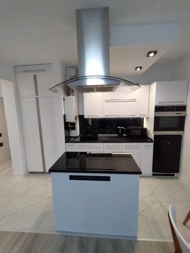 a kitchen with white cabinets and a stove top oven at MG Apartament Elfów in Tychy