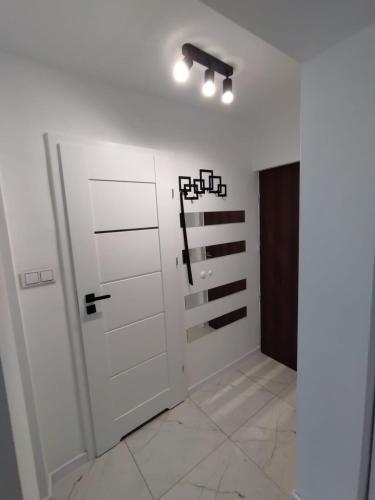 a white room with a closet and a door at MG Apartament Elfów in Tychy