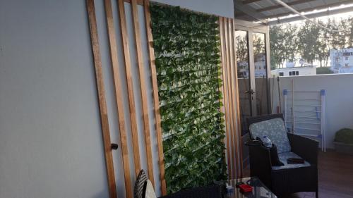 a room with a green wall with a chair at Apartment in Flic en Flac of 68 m² with pool in Flic-en-Flac