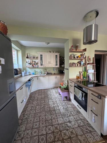 a kitchen with white cabinets and a tile floor at 3 room apartment with castle view in Trenčín