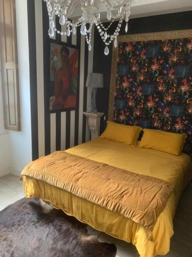 une chambre avec un lit avec un tableau sur le mur dans l'établissement Les flots dorées, à Bergerac