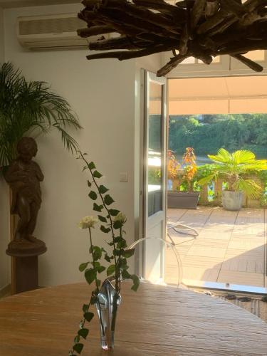 un vase assis sur une table avec une plante dans l'établissement Les flots dorées, à Bergerac