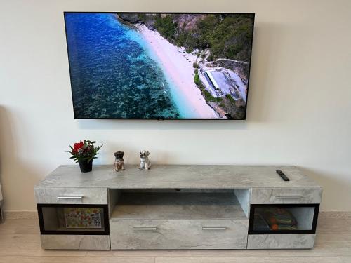 a television hanging on a wall above a table at KOMFORT FerienWohnung NeuBau Merzig in Merzig