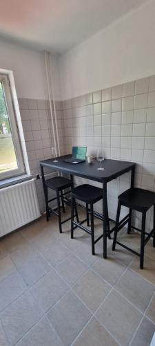 a black table with two chairs and a laptop on it at Southern Sun in Tilburg