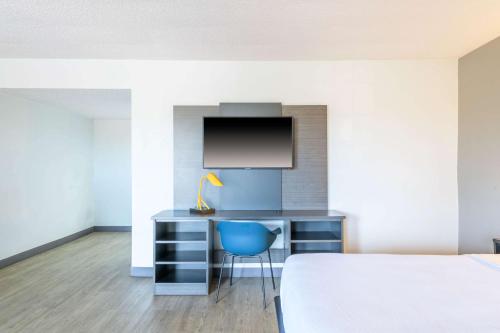 a bedroom with a desk and a blue chair at Motel 6-Ocala, FL - Conference Center in Ocala Ridge