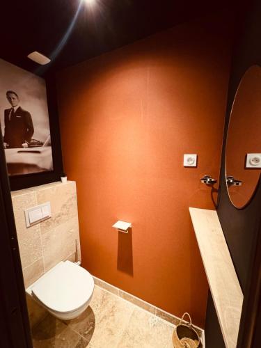 une salle de bain avec toilettes et un tableau au mur dans l'établissement Cinema room 3 min de Beaune, à Vignoles