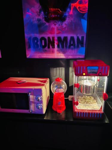 un micro-ondes et un jouet sur un comptoir dans l'établissement Cinema room 3 min de Beaune, à Vignoles