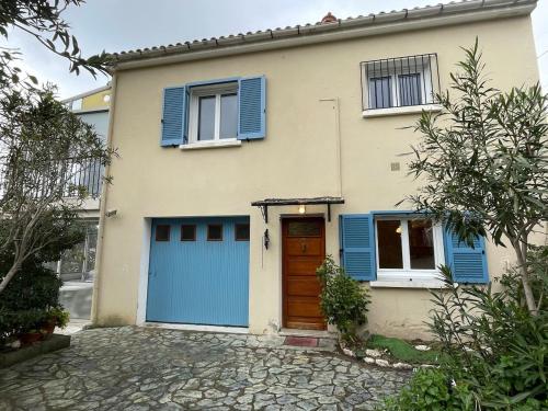een huis met blauwe luiken en een blauwe garage bij Casa Nunziada in Patrimonio Garden level, Quiet and Bright in Patrimonio