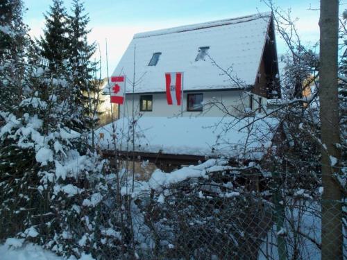 a house is covered in snow with a fence at Villa Wellspacher Luxury Apartments Semmering in Semmering