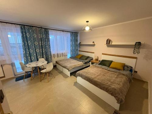 a bedroom with two beds and a table at Willa Turnia Karpacz in Karpacz